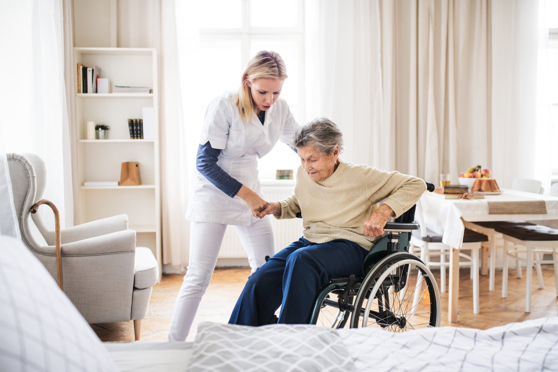 A support worker assisting an older woman at home