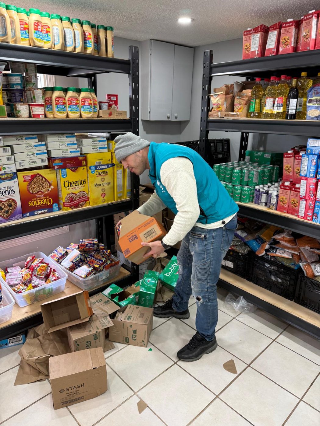 A volunteer sorting donated food onto shelves at a food bank